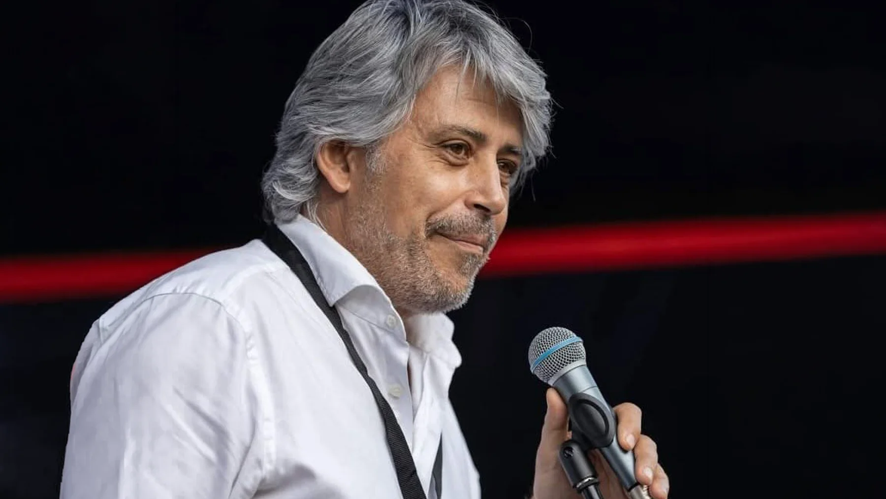 Portrait of Andrei Pena holding a microphone