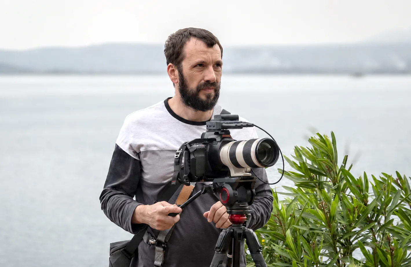Portrait of Andrei Popa with a video camera by the water